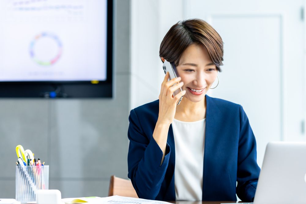 スマホで電話をする女性のビジネスマン