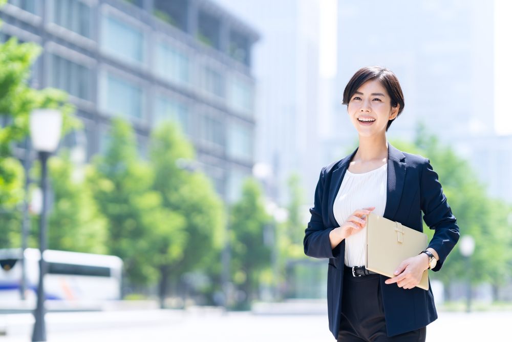 笑顔で歩くスーツを着た女性